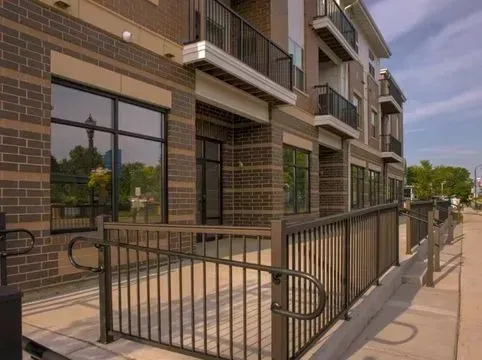 Building exterior with brick and windows, accessible ramp with metal railing.