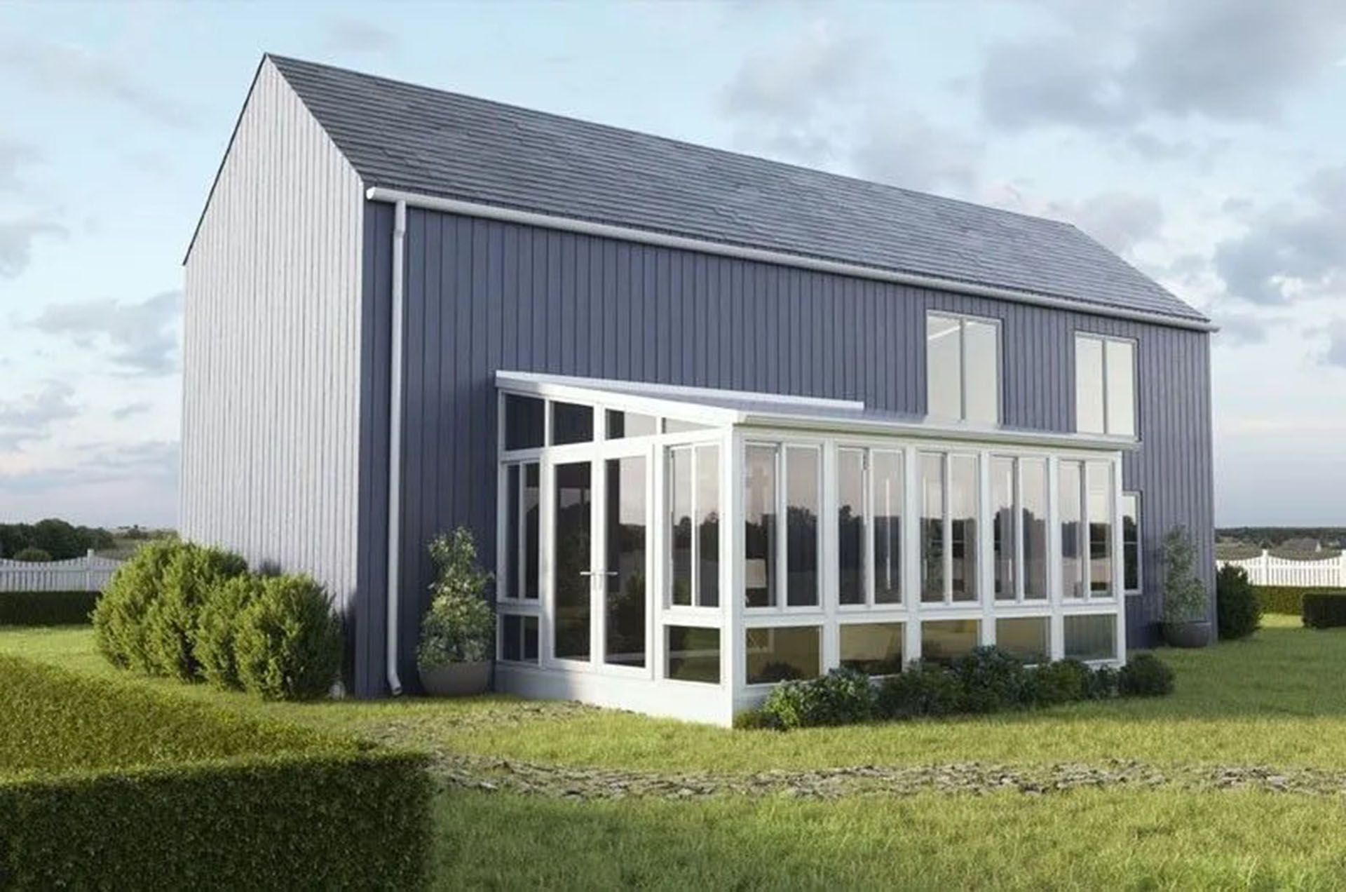 A modern blue house with a white sunroom, surrounded by green hedges and grass under a cloudy sky.