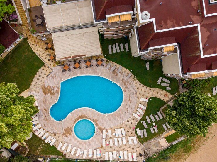 An aerial view of a hotel with a large swimming pool