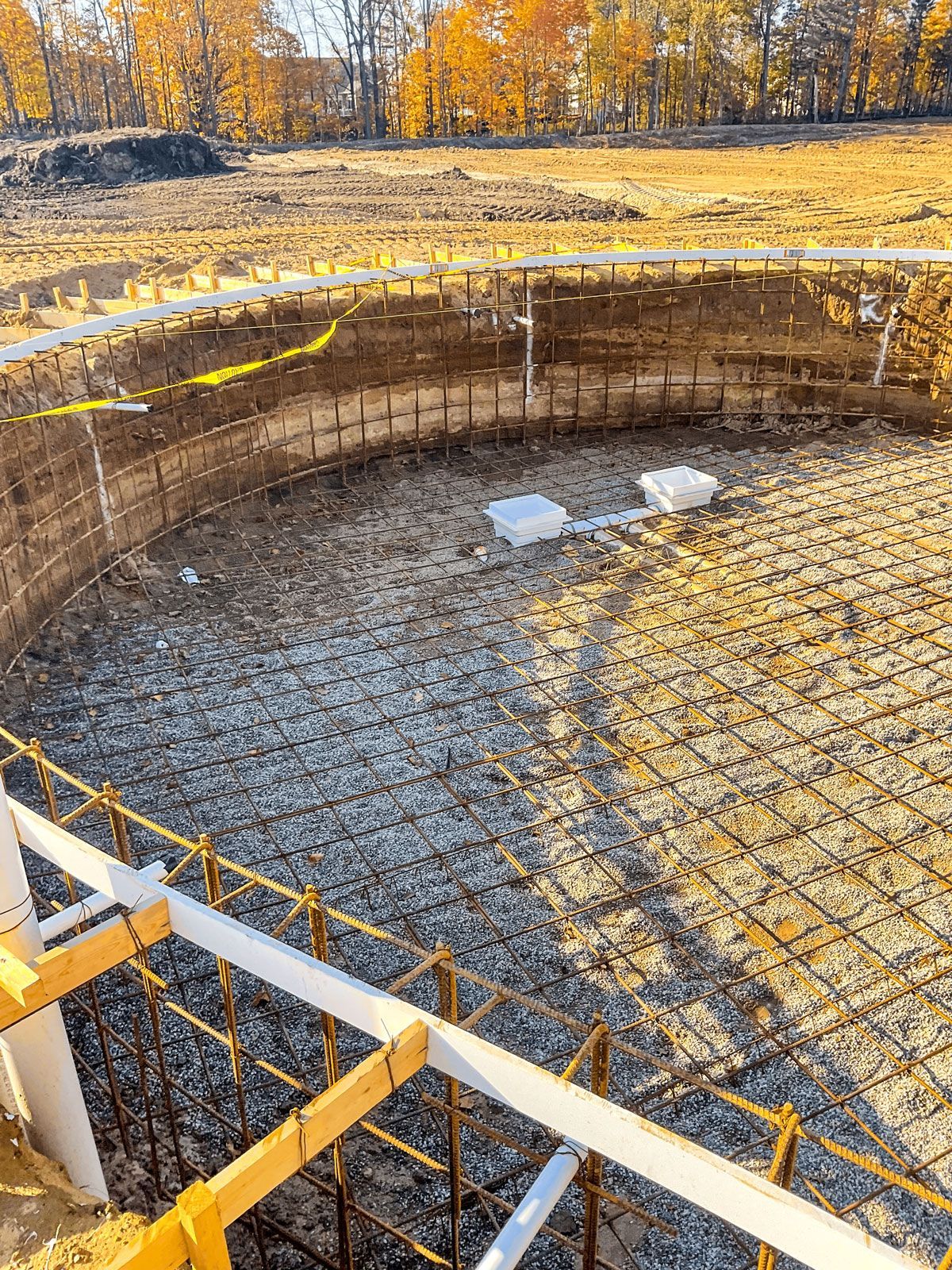A large hole in the ground is being filled with concrete.