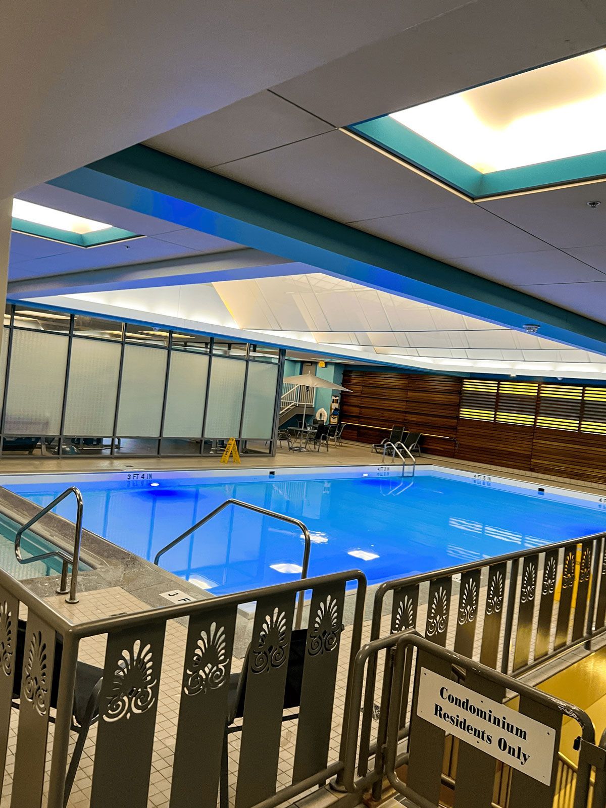 A large indoor swimming pool with stairs leading to it.