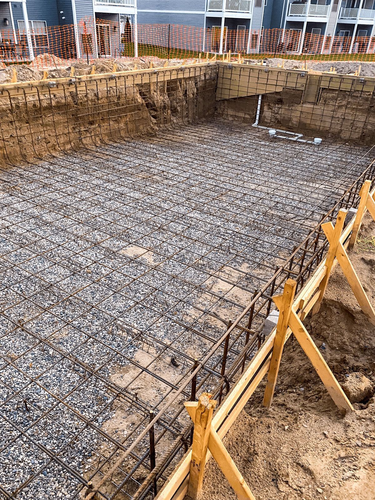 A swimming pool is being built in the backyard of a house.