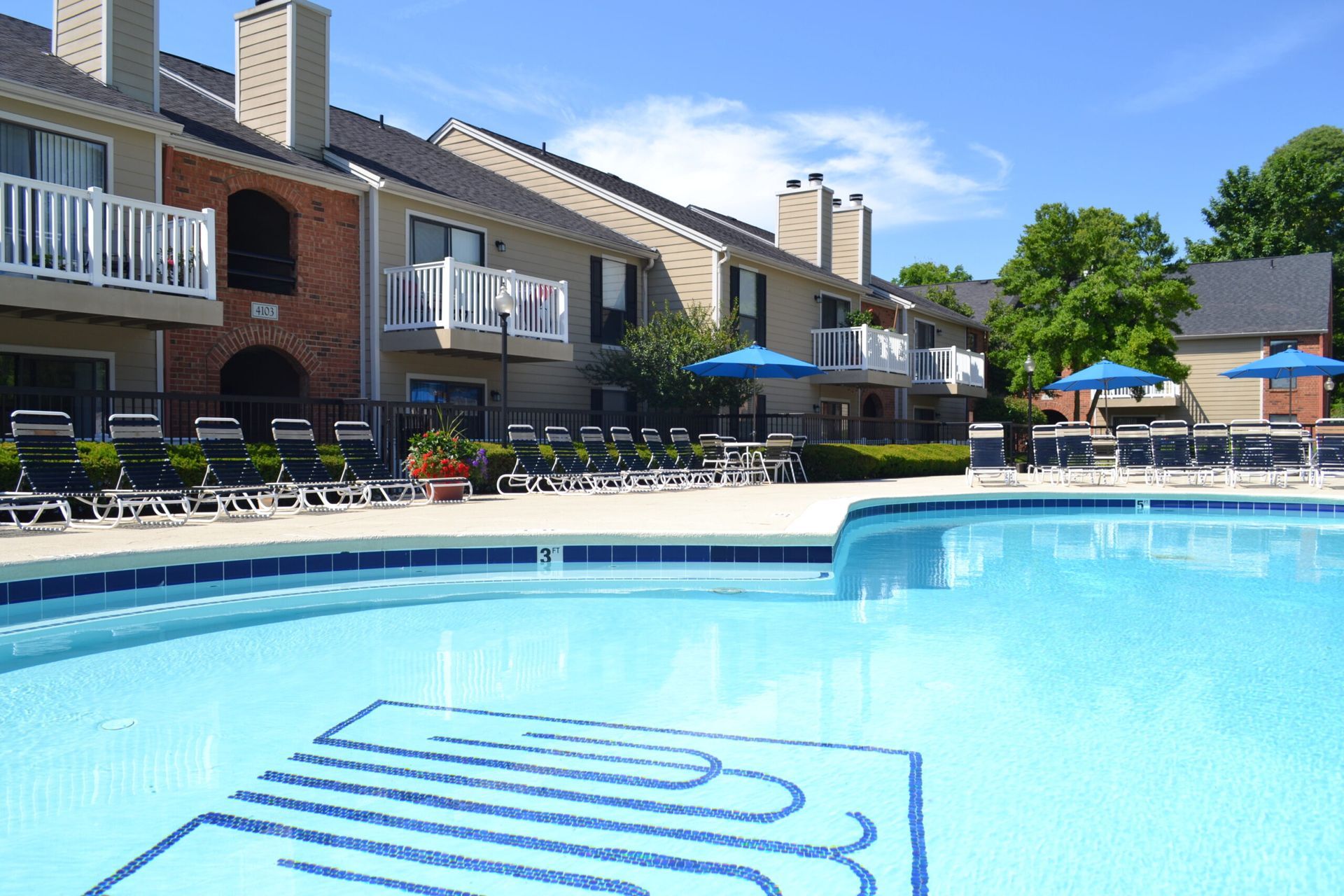 A large swimming pool surrounded by chairs and umbrellas