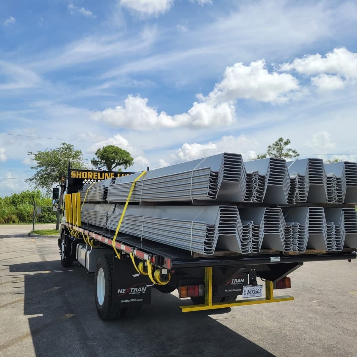 A truck is carrying a stack of steel beams on the back of it