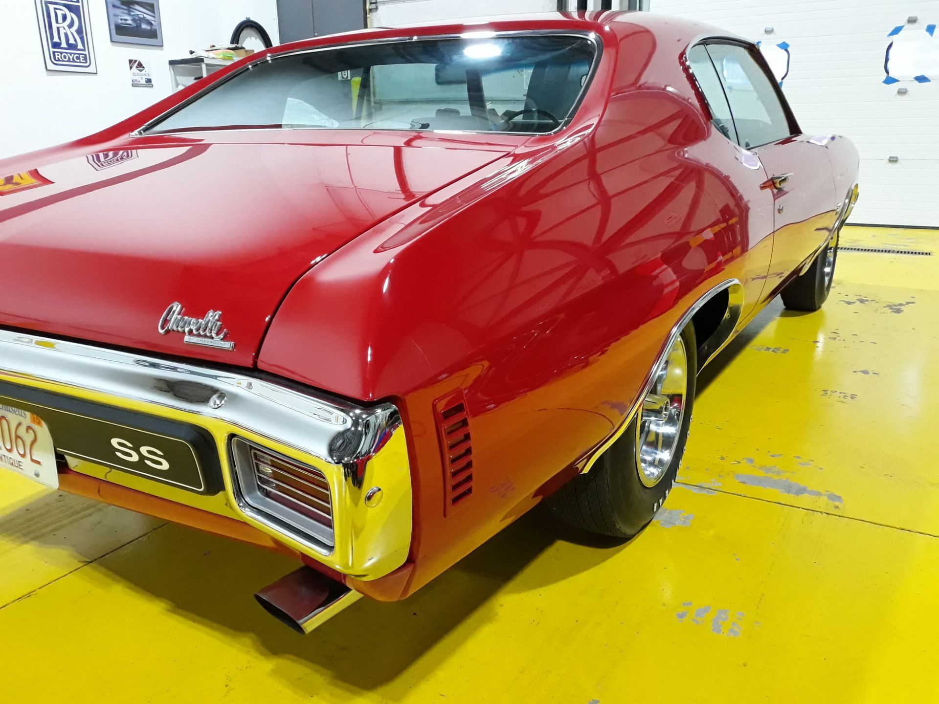 Red vintage sports car on a bright yellow floor in a white showroom
