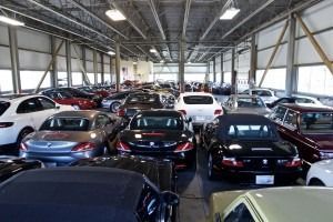 Rows of parked cars inside a large indoor garage or warehouse