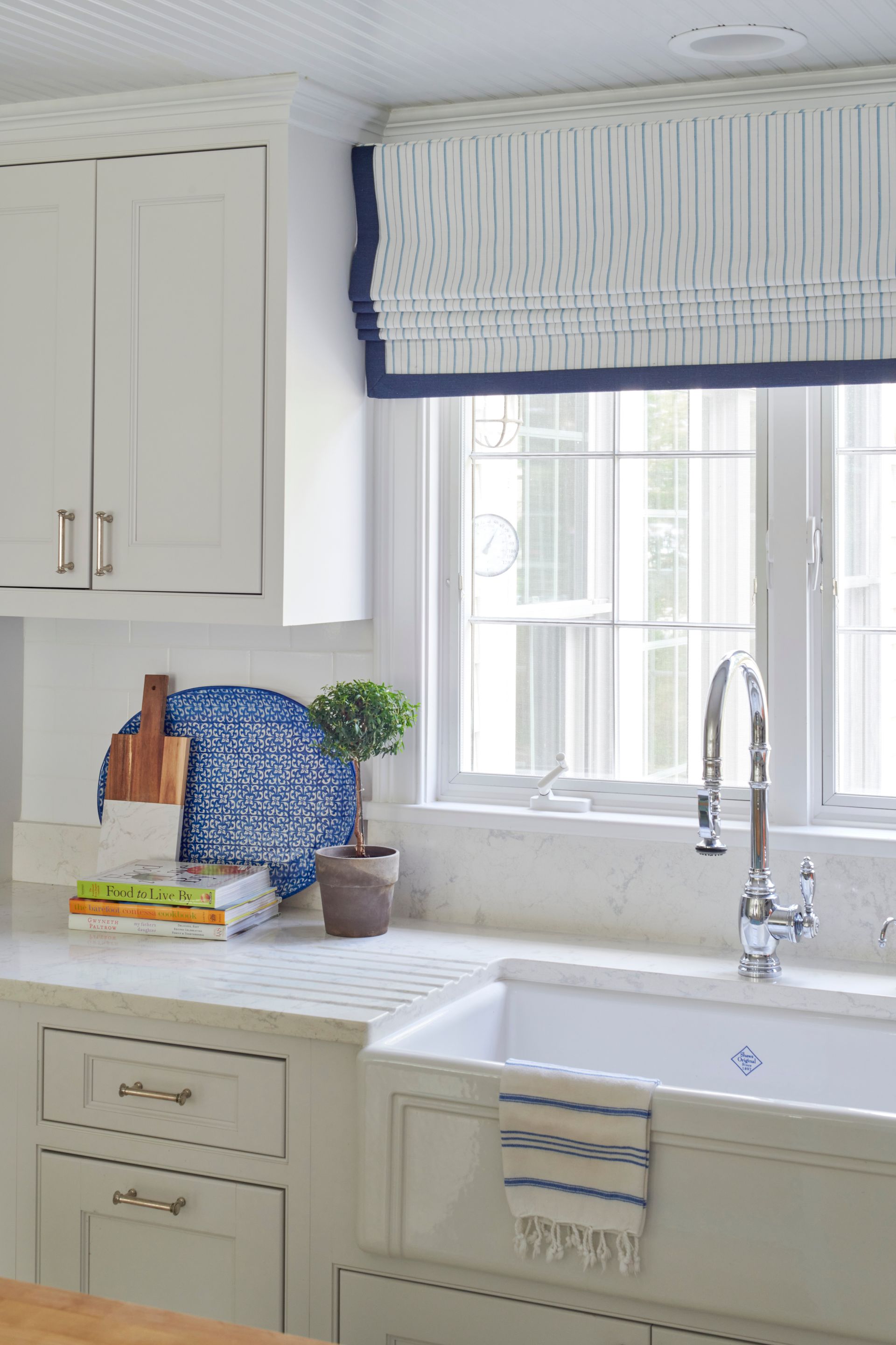 A kitchen with a sink, cabinets, and a window
