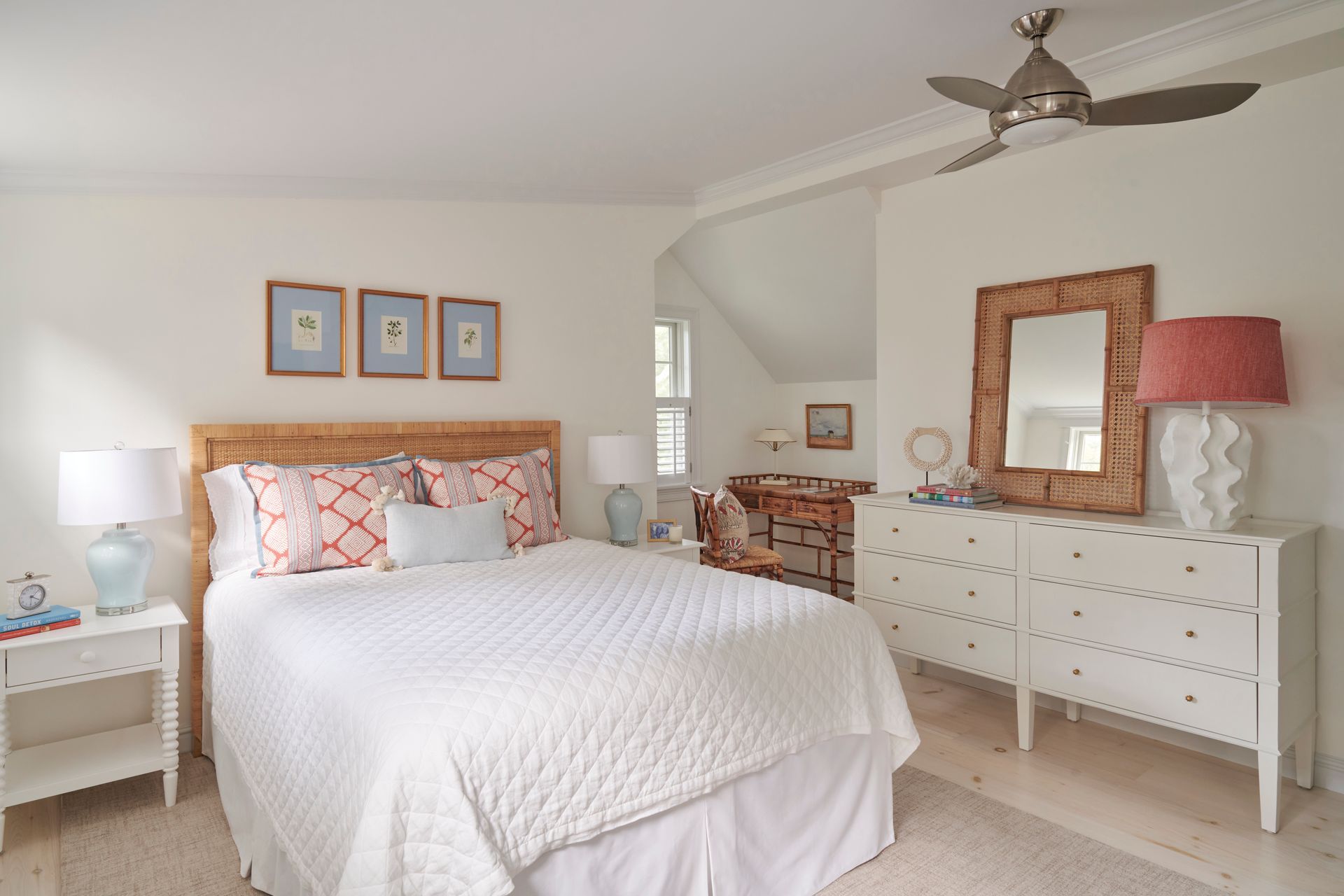 A bedroom with a bed, dresser, nightstand, mirror and a ceiling fan