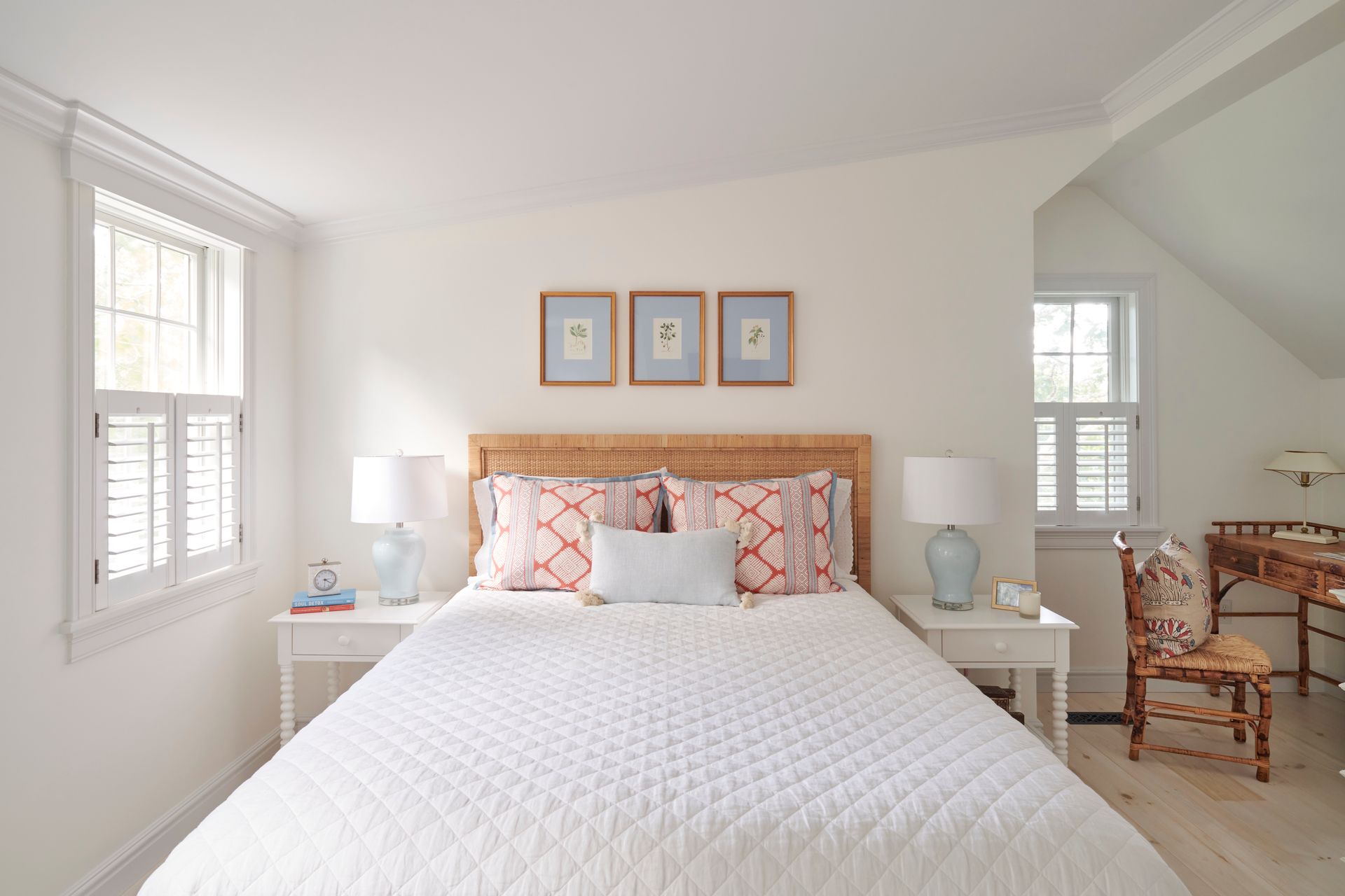 Bedroom with a bed, two nightstands, two lamps, and three pictures on the wall