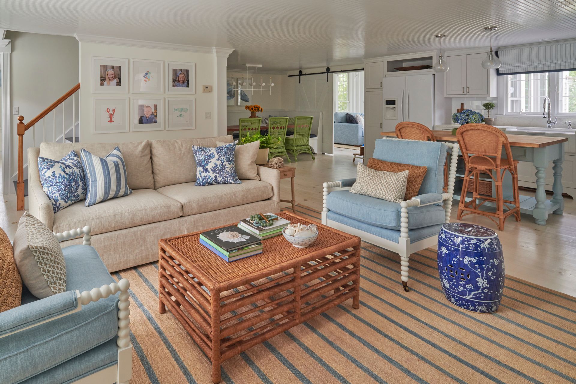A living room with a couch, chairs, coffee table, and rug