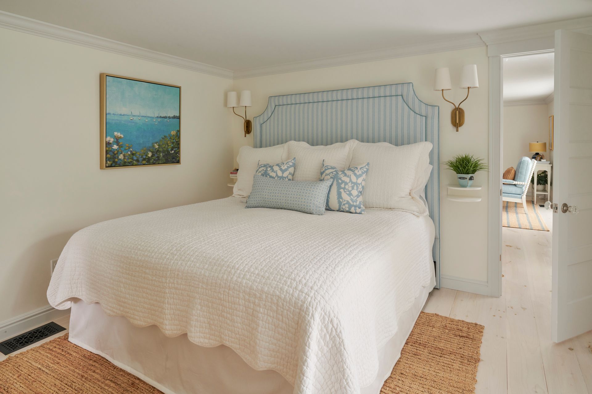 A bedroom with a large bed and a painting on the wall
