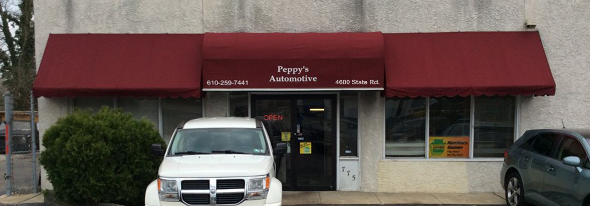 Front of Peppy's Automotive with white and black cars