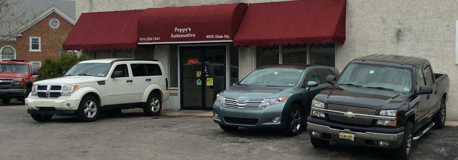 Front of Peppy's Automotive with four cars