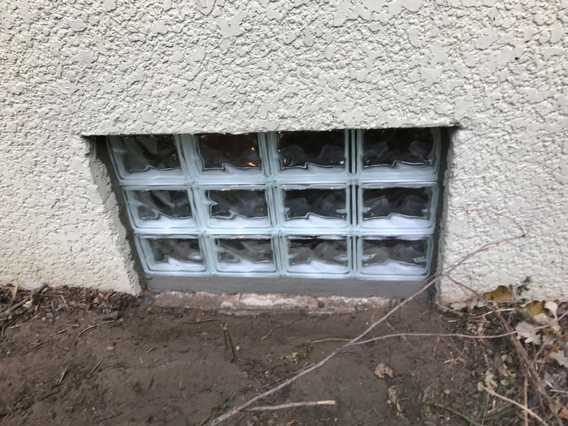 Glass block window in stucco wall.