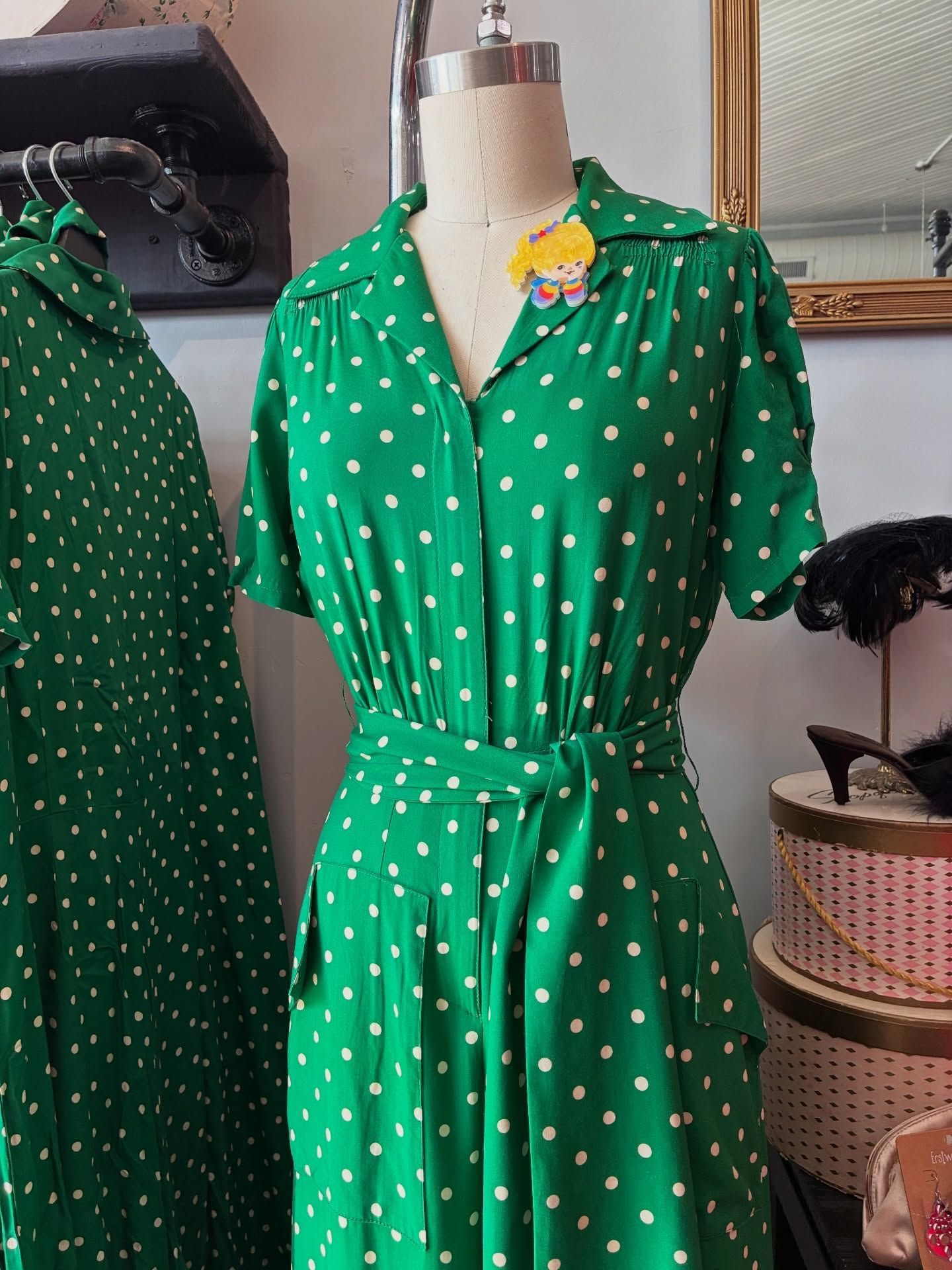 Green polka dot dress on a mannequin, with belt
