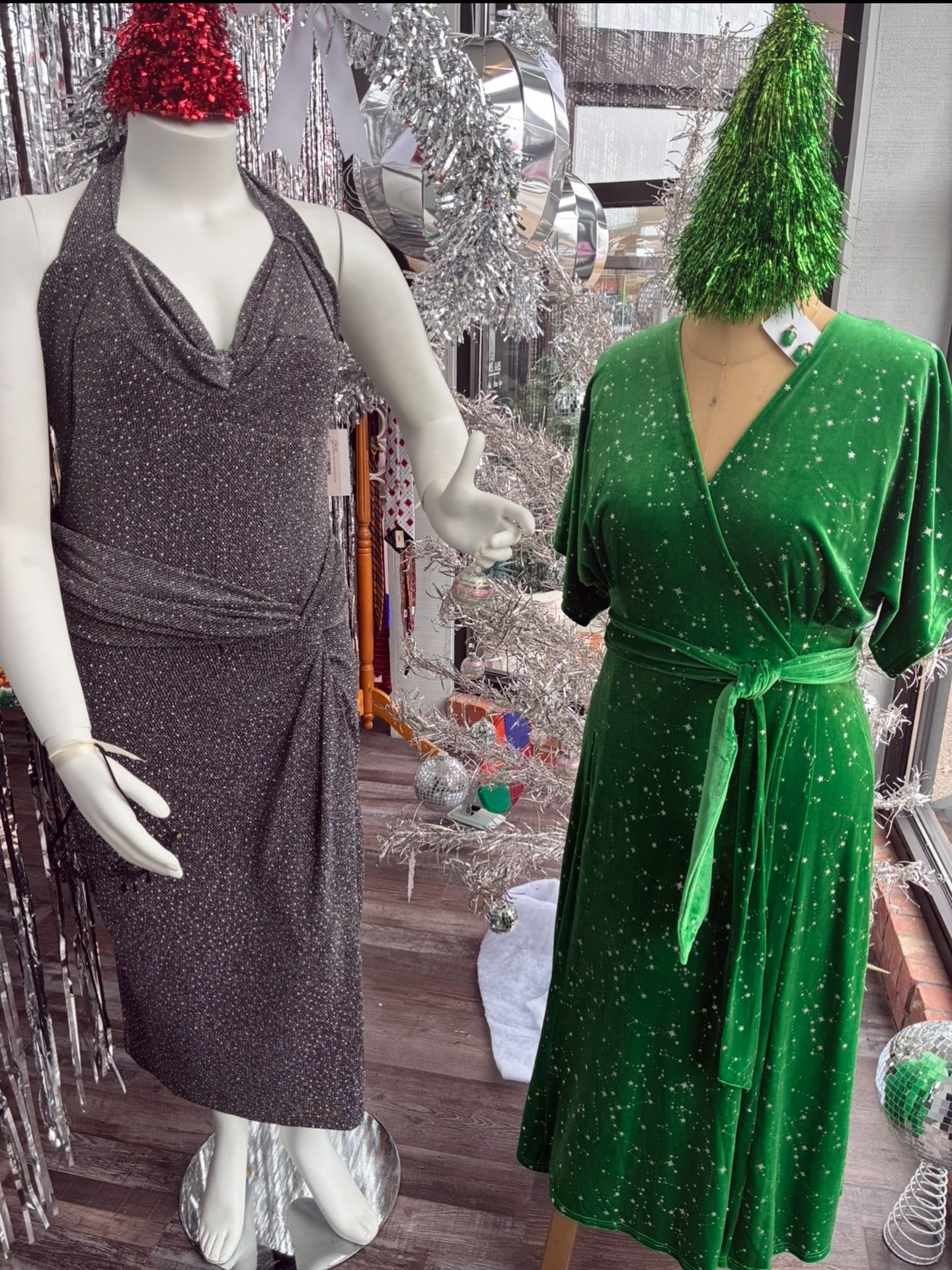 Two mannequins in dresses; one silver, one green