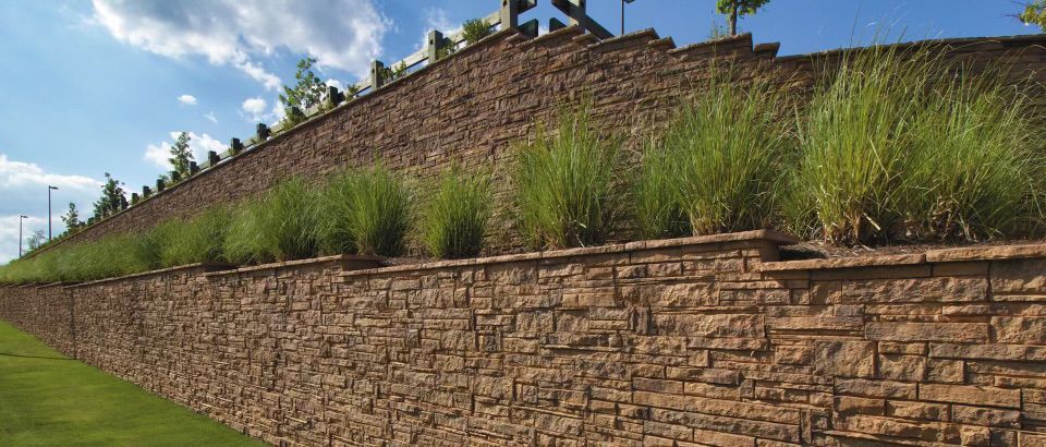 A large stone wall surrounds a grassy hillside