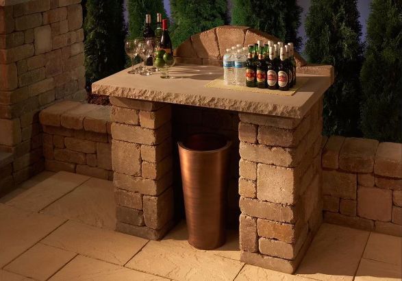 A brick table with bottles of beer and wine on it