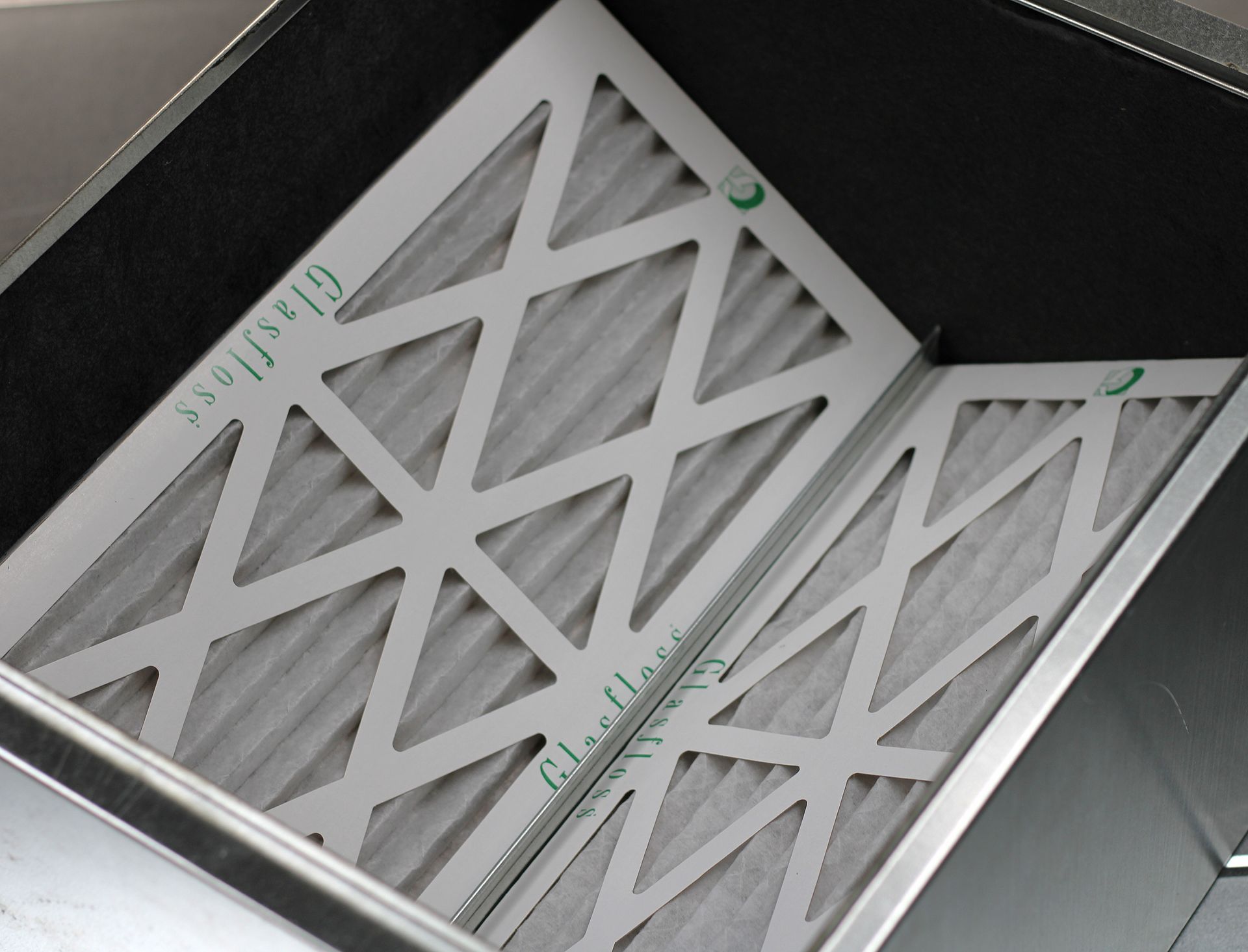 White vent or filter panels with diagonal lattice pattern in a metallic frame.