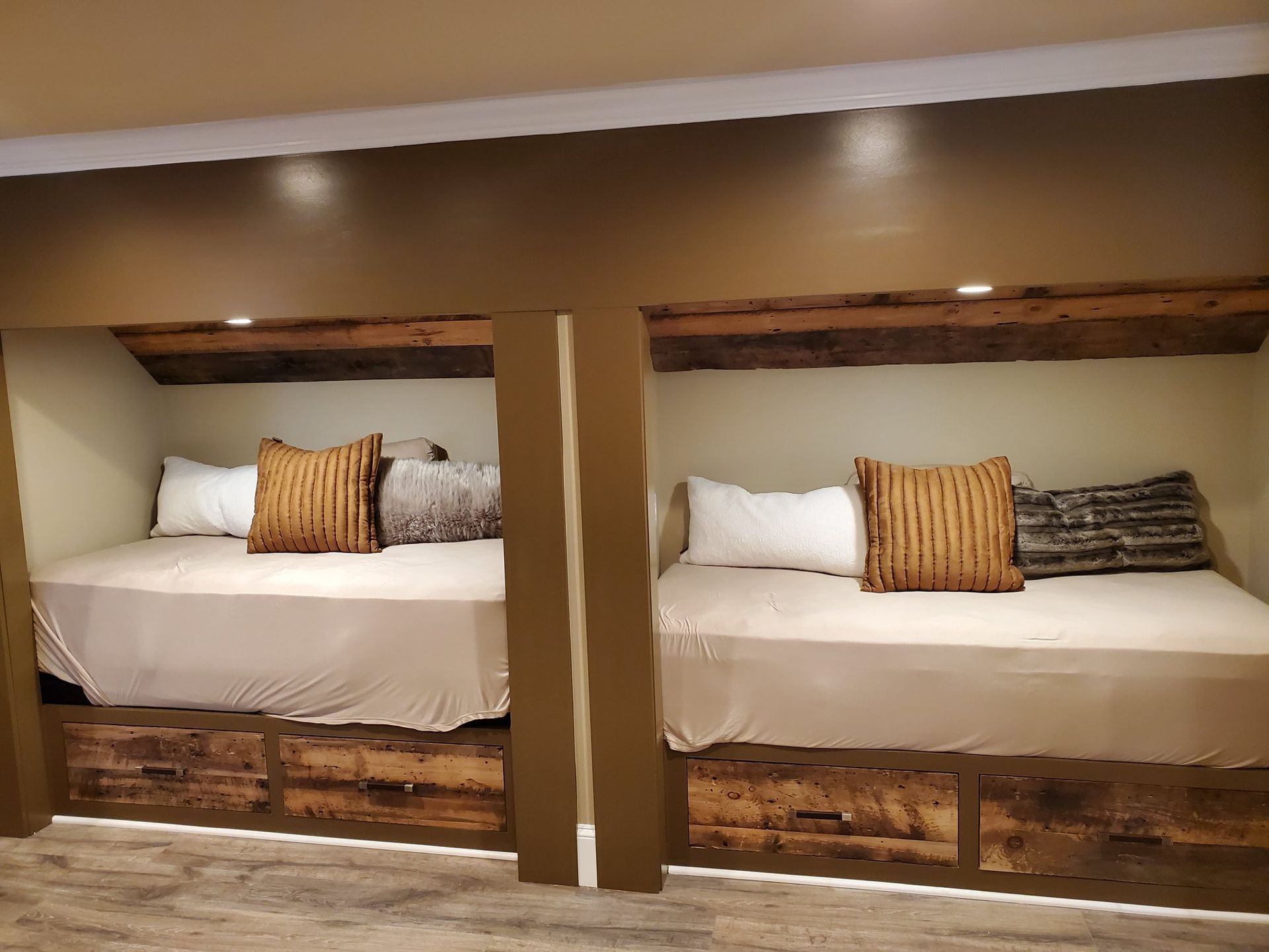 Two built-in beds with storage drawers, wooden headboards, and neutral bedding.