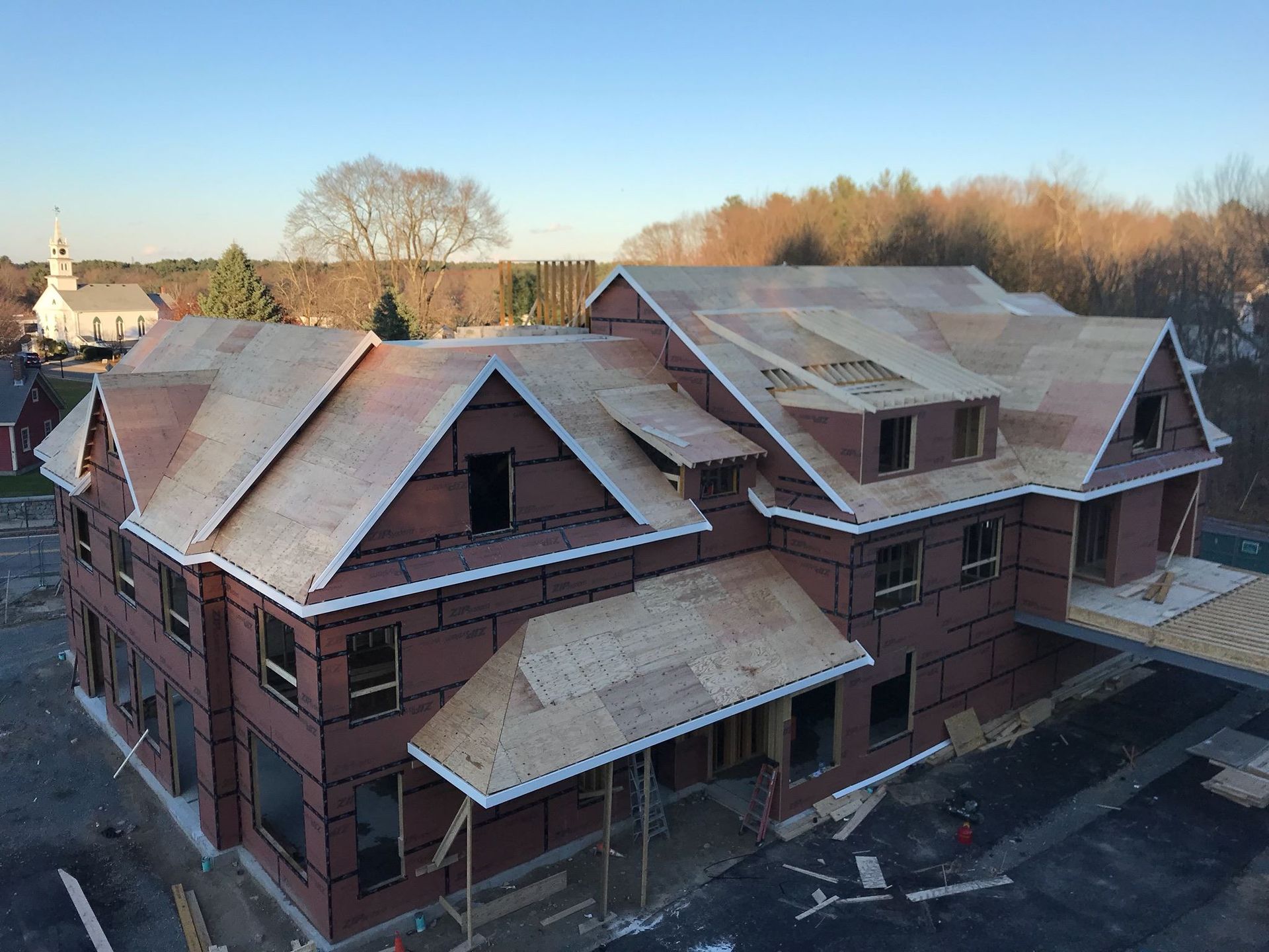 Multi-story building under construction with exposed wood framing.