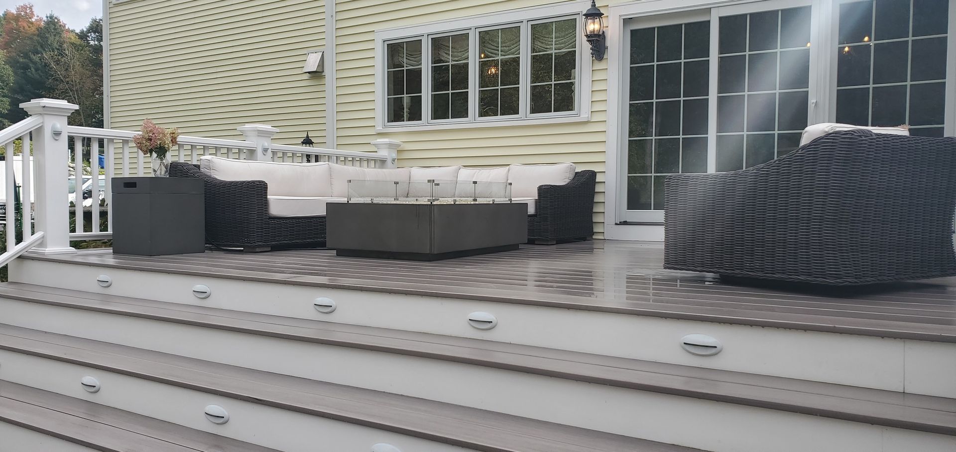 Composite deck with outdoor furniture and a house in the background.