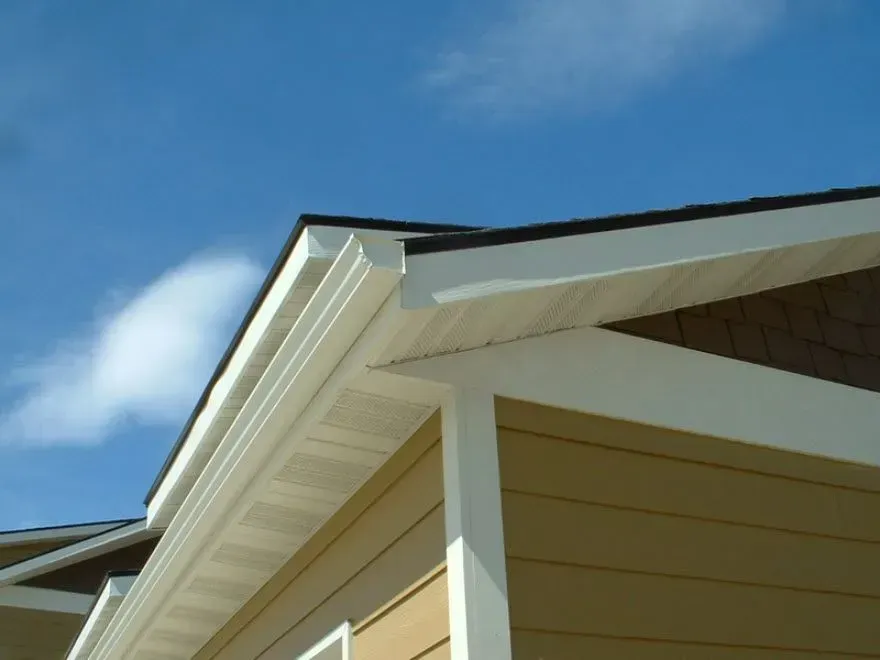 Close-up of a house roof and eaves against a blue sky