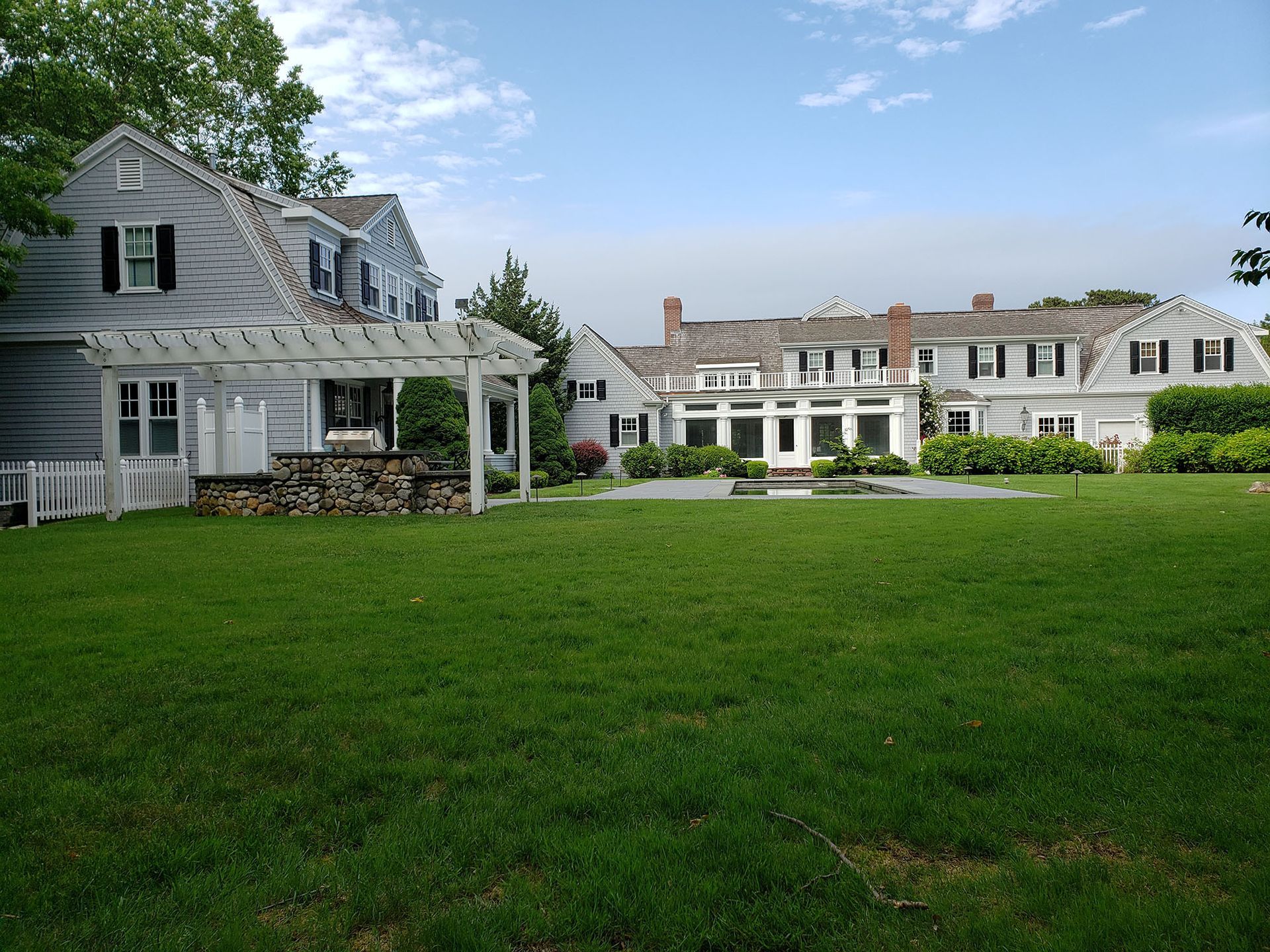 White seaside resort buildings with a large green lawn under a blue sky