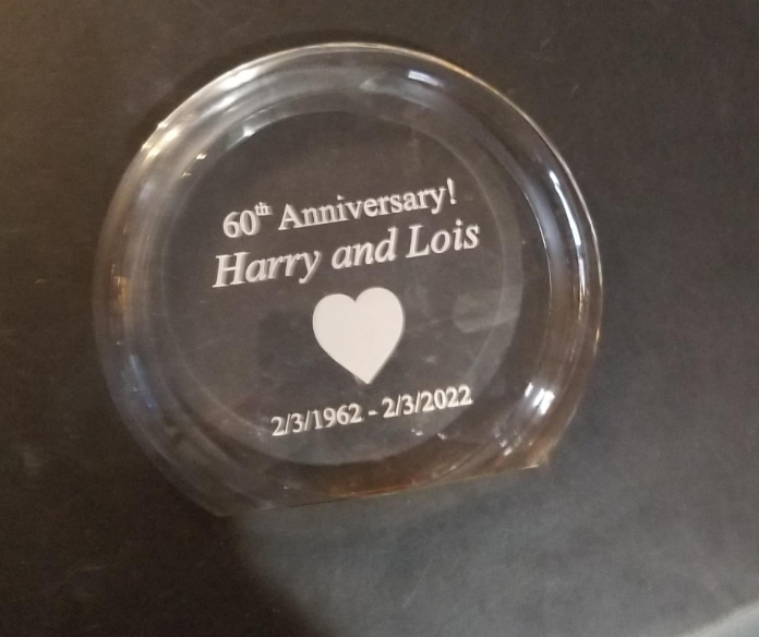 Clear glass paperweight with engraved text: 
