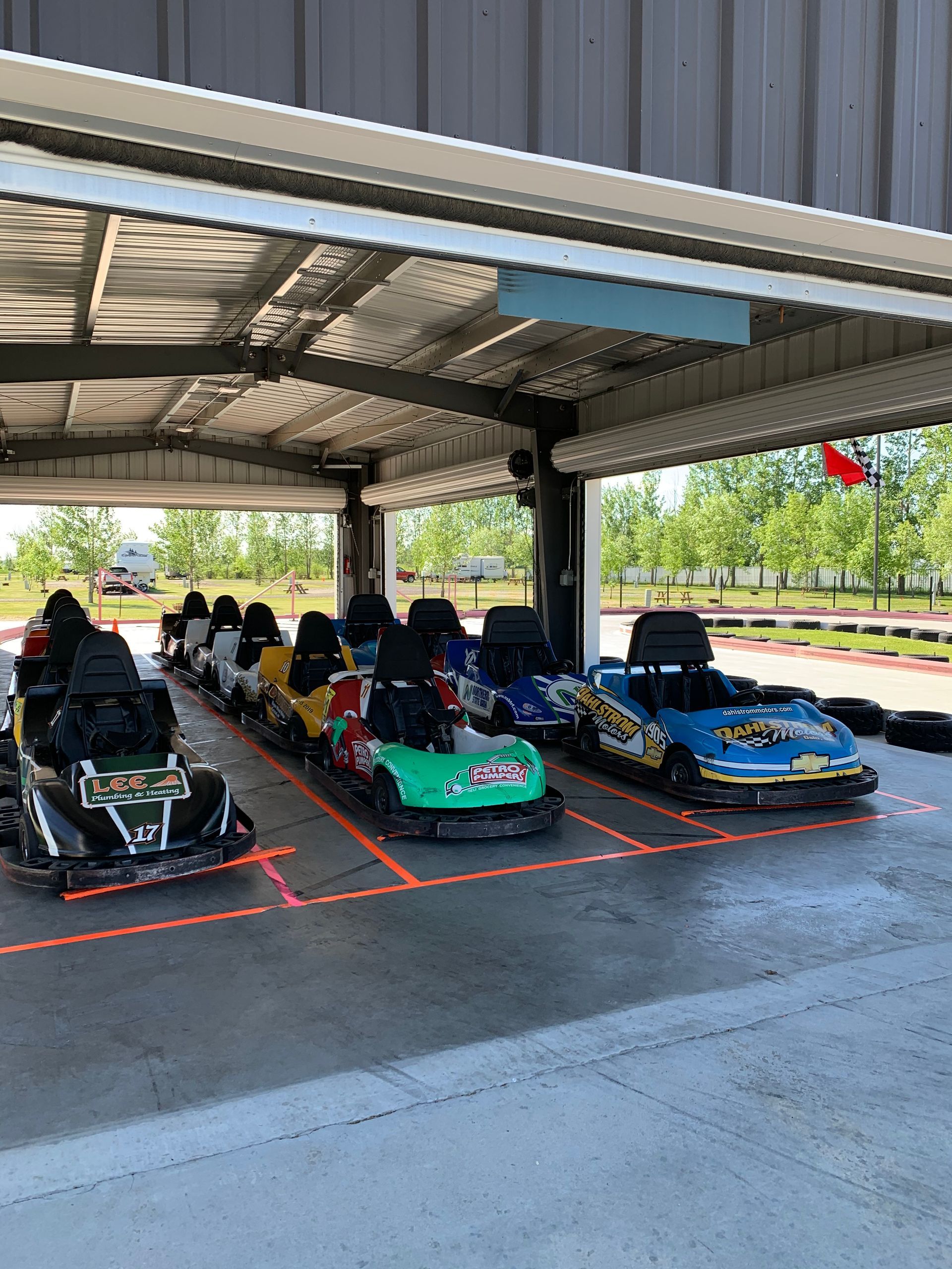 A row of go karts are parked in a garage.