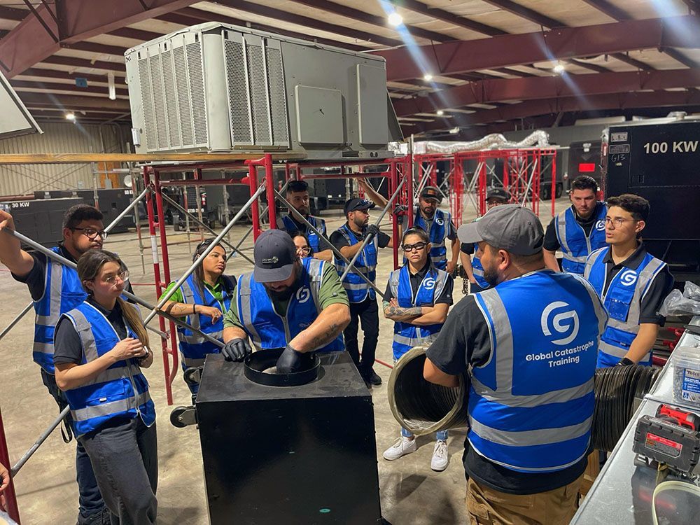 People in blue safety vests gather around a large industrial machine in a workshop, inspecting it together.