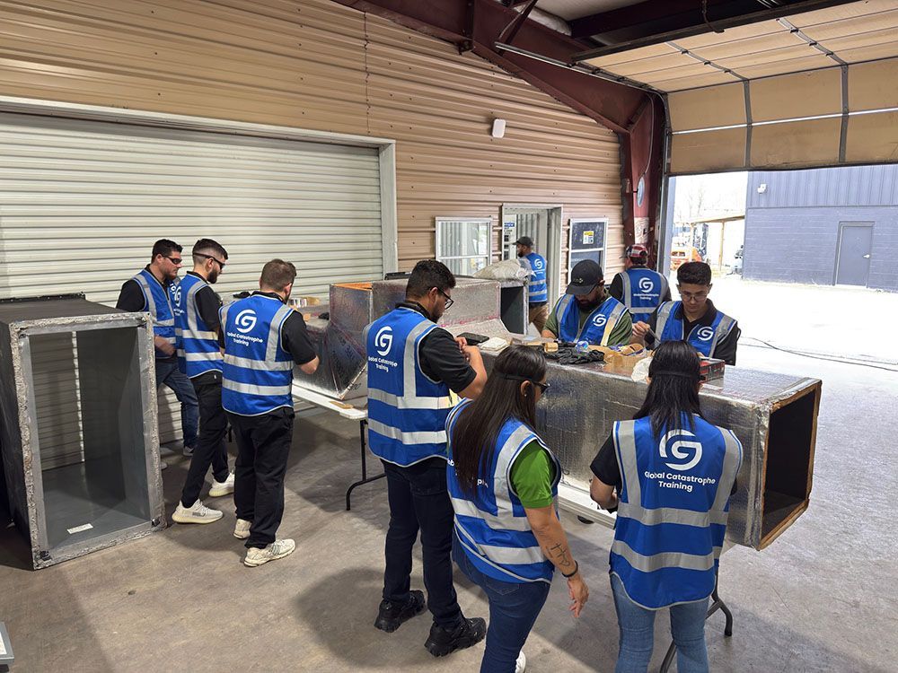 Workers in blue safety vests moving large crates inside a warehouse loading area.