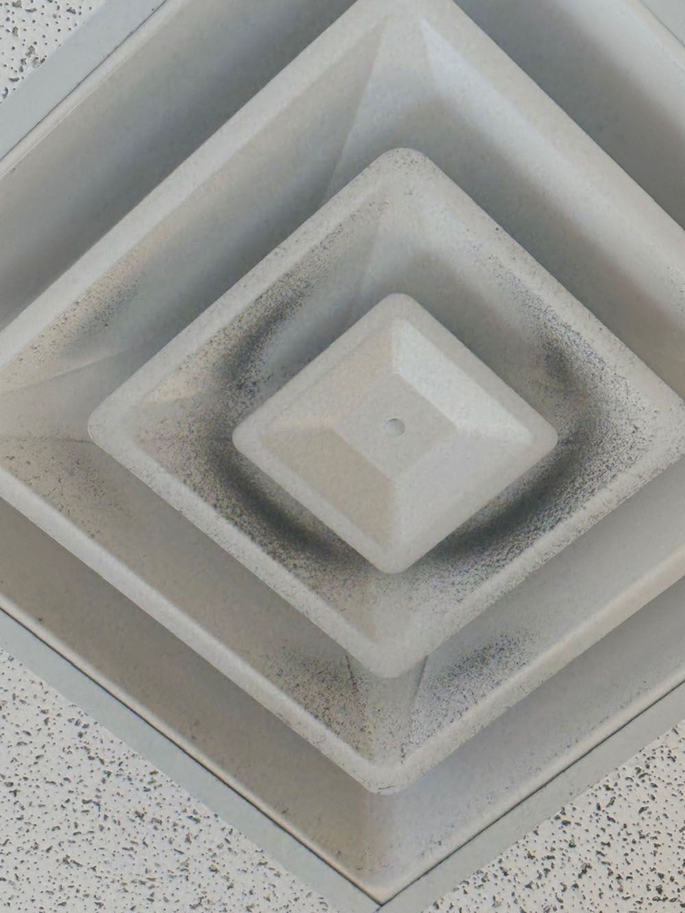 Abstract geometric ceiling vent with layered square frames in white and gray