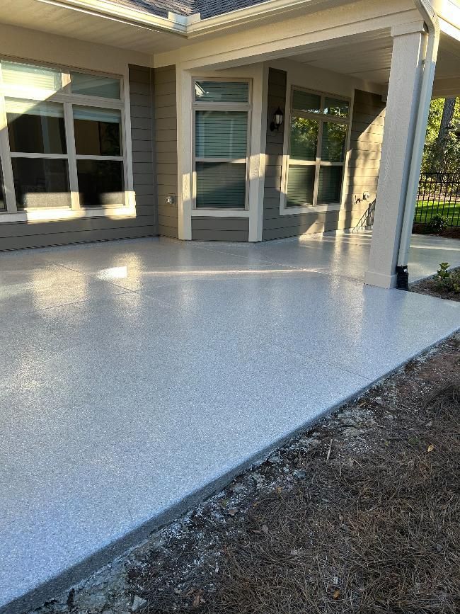 A patio with a concrete floor in front of a house.
