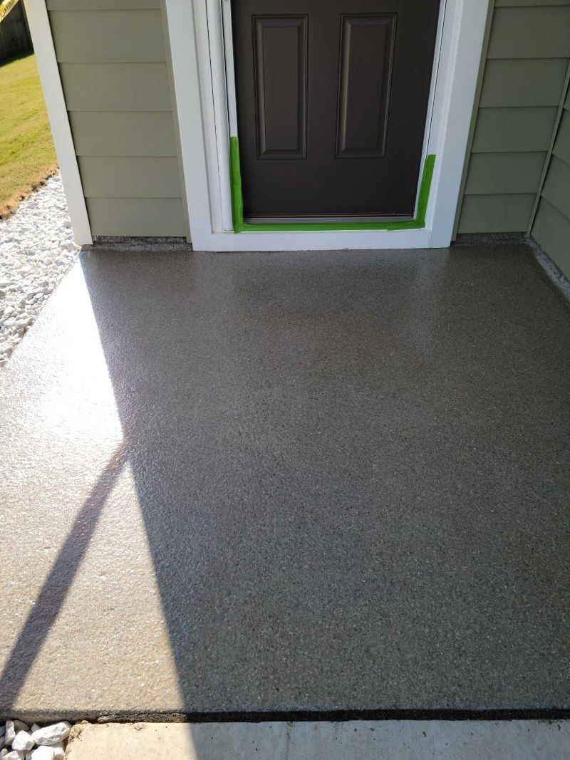 A concrete porch with a door and a shadow on it.