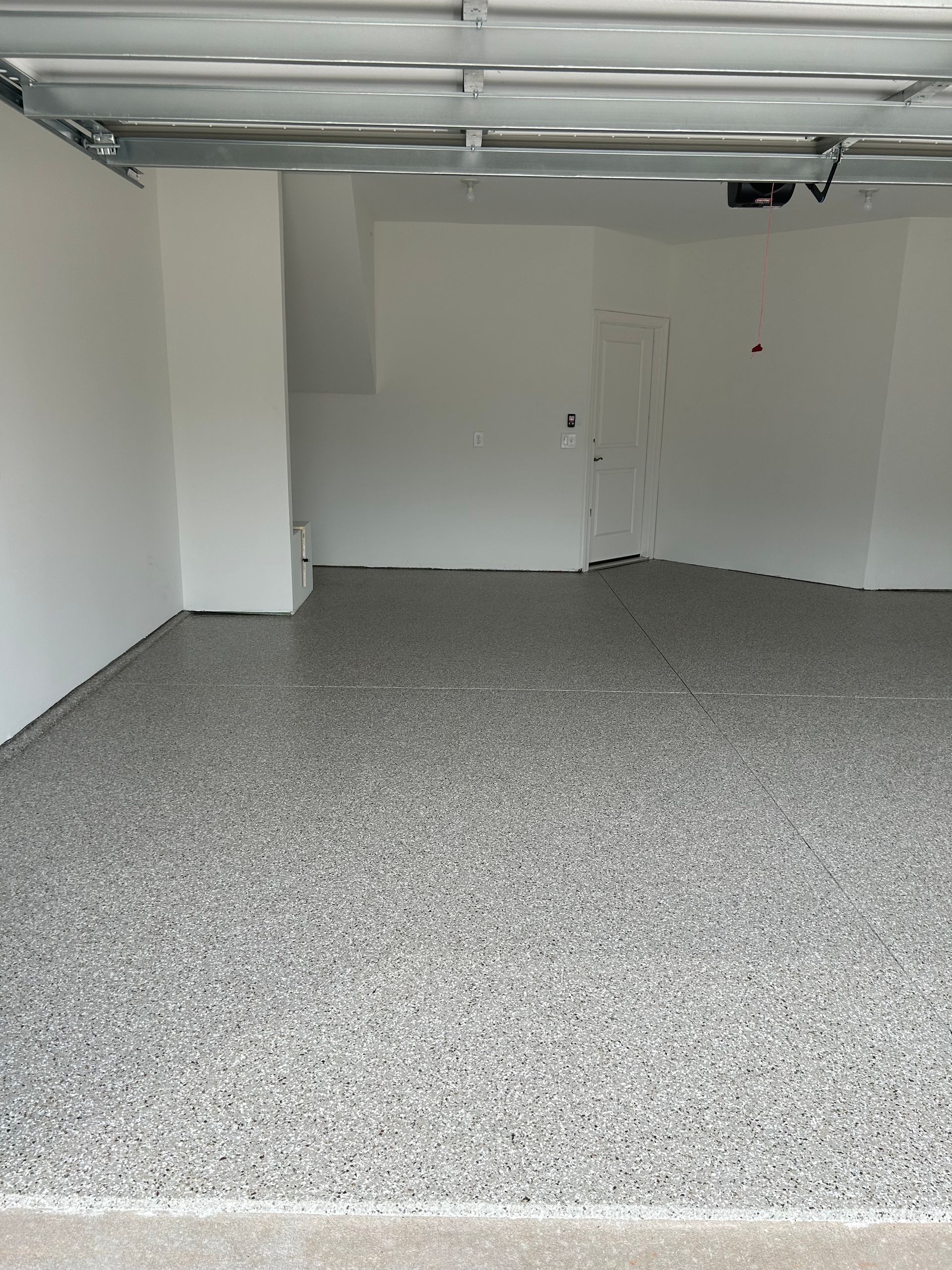 A garage with a gray floor and white walls.