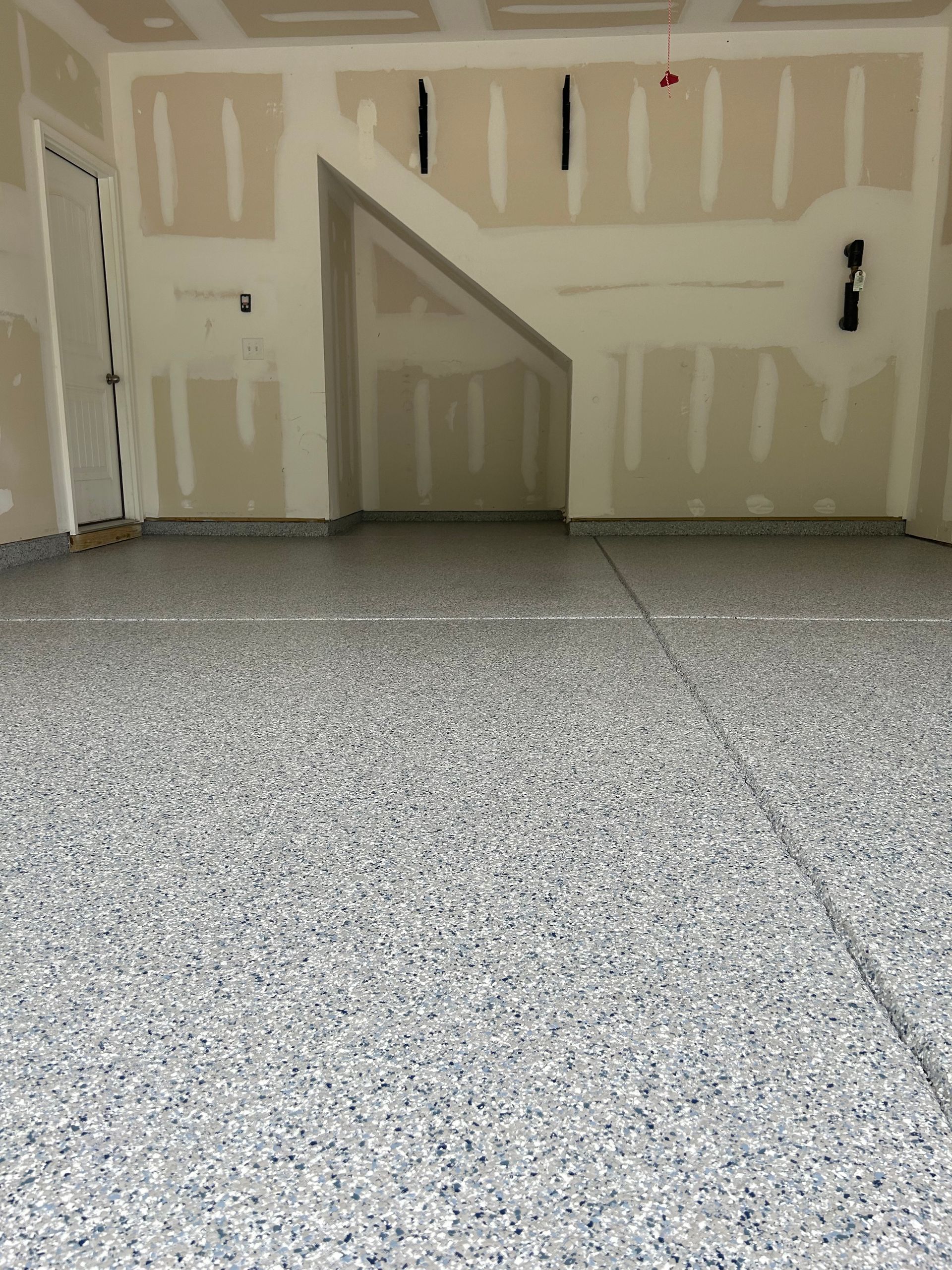 A garage with a staircase and a gray floor