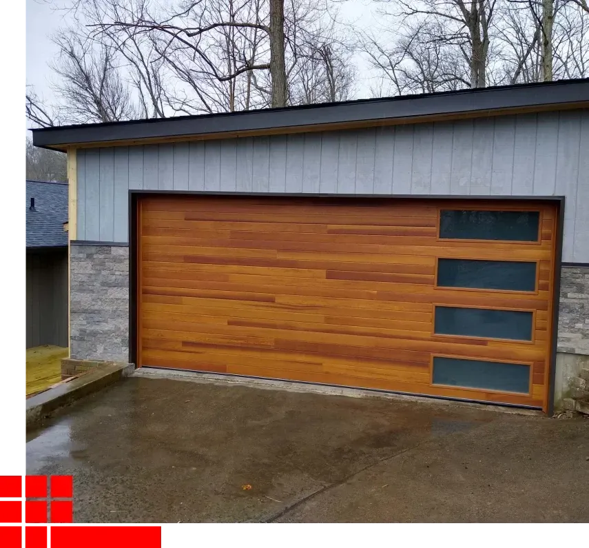 Modern garage with a wood-tone door and three narrow frosted windows on the right, set in a driveway.