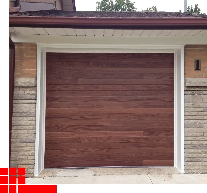 Closed brown wooden garage door with white trim on a brick house exterior