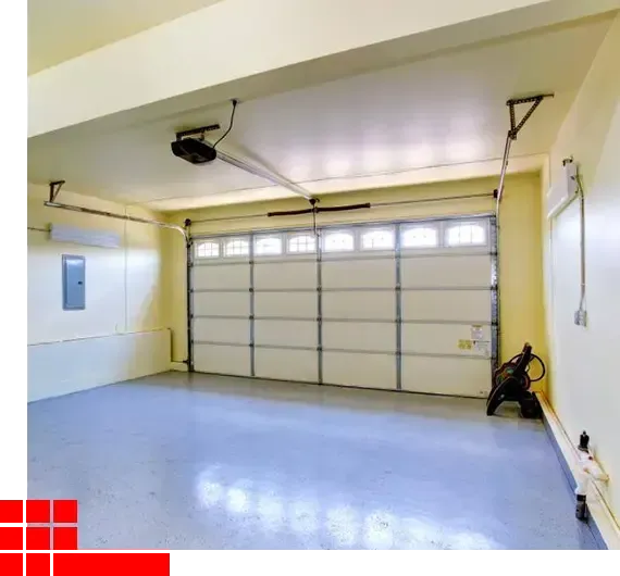 Empty two-car garage with a blue floor, white walls, and a closed gray garage door.