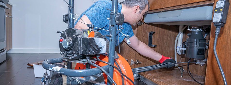 A man cleaning a clogged drain