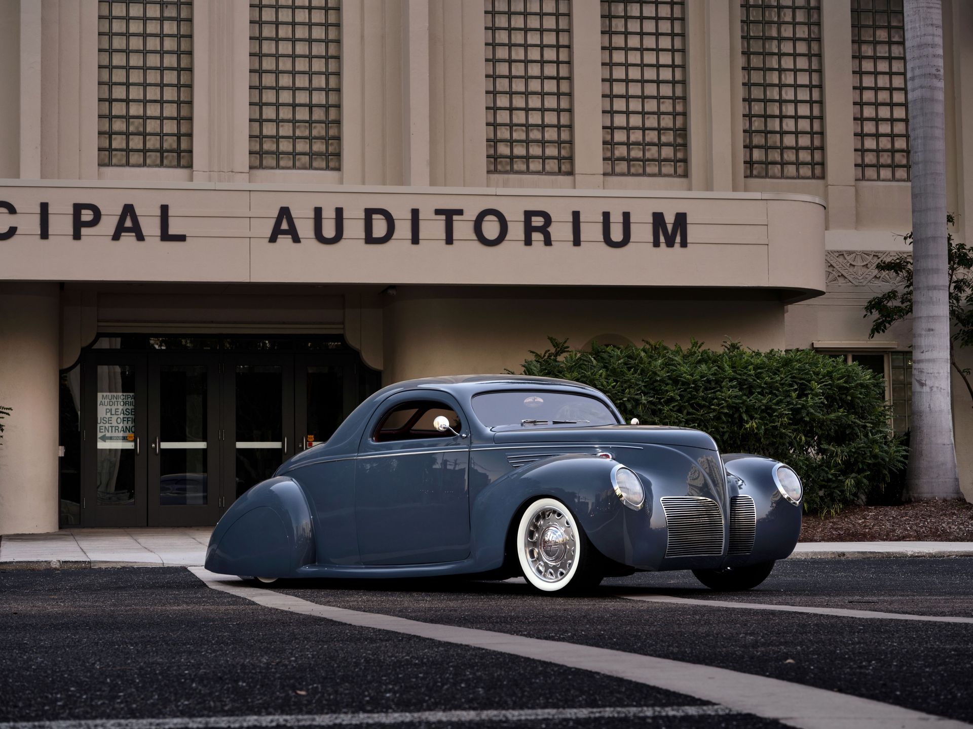 A car is parked in front of the municipal auditorium