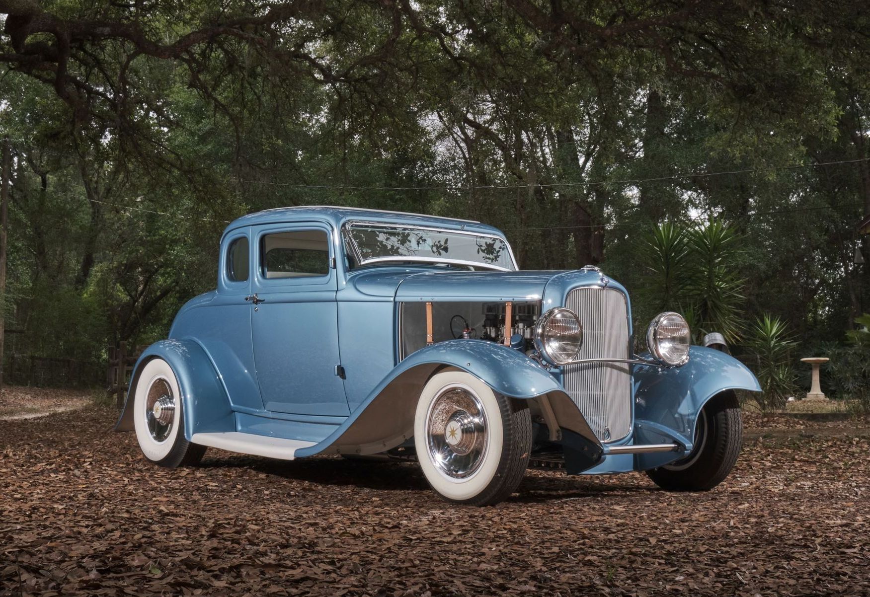 A blue car is sitting on a cart in a garage.
