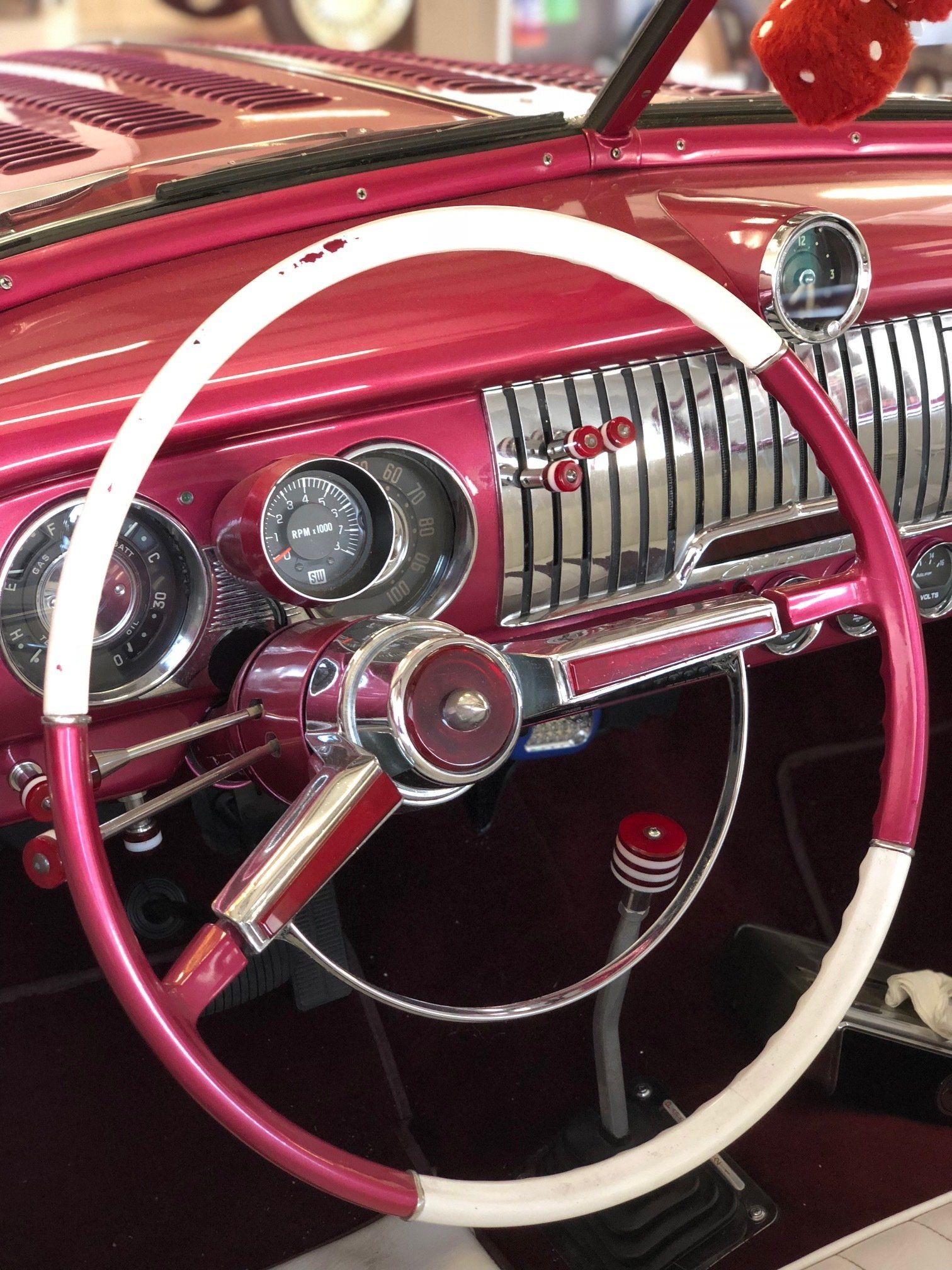 A pink car with a white steering wheel