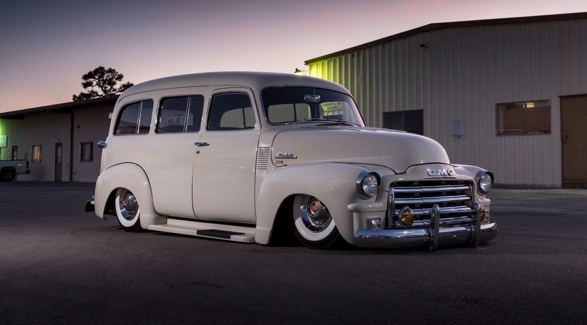A white van is parked in front of a building