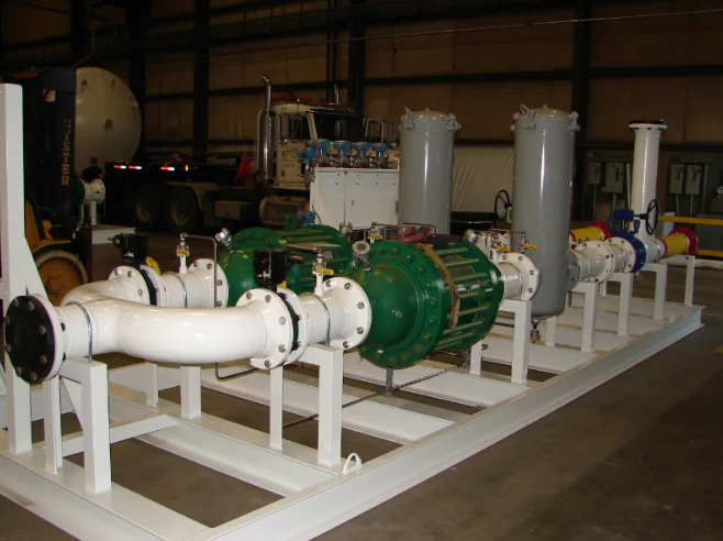 White and green industrial pump system with piping and filtration, mounted on a white steel frame, in a warehouse.