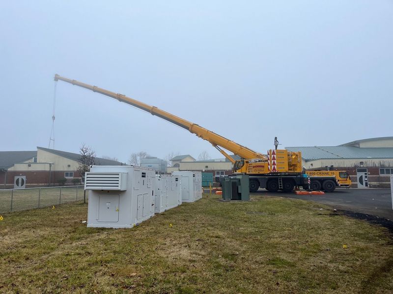 A crane lifting equipment near a building on a foggy day.