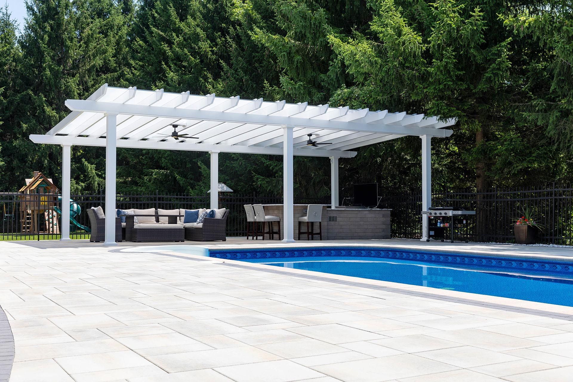 A white pergola covers an outdoor lounge