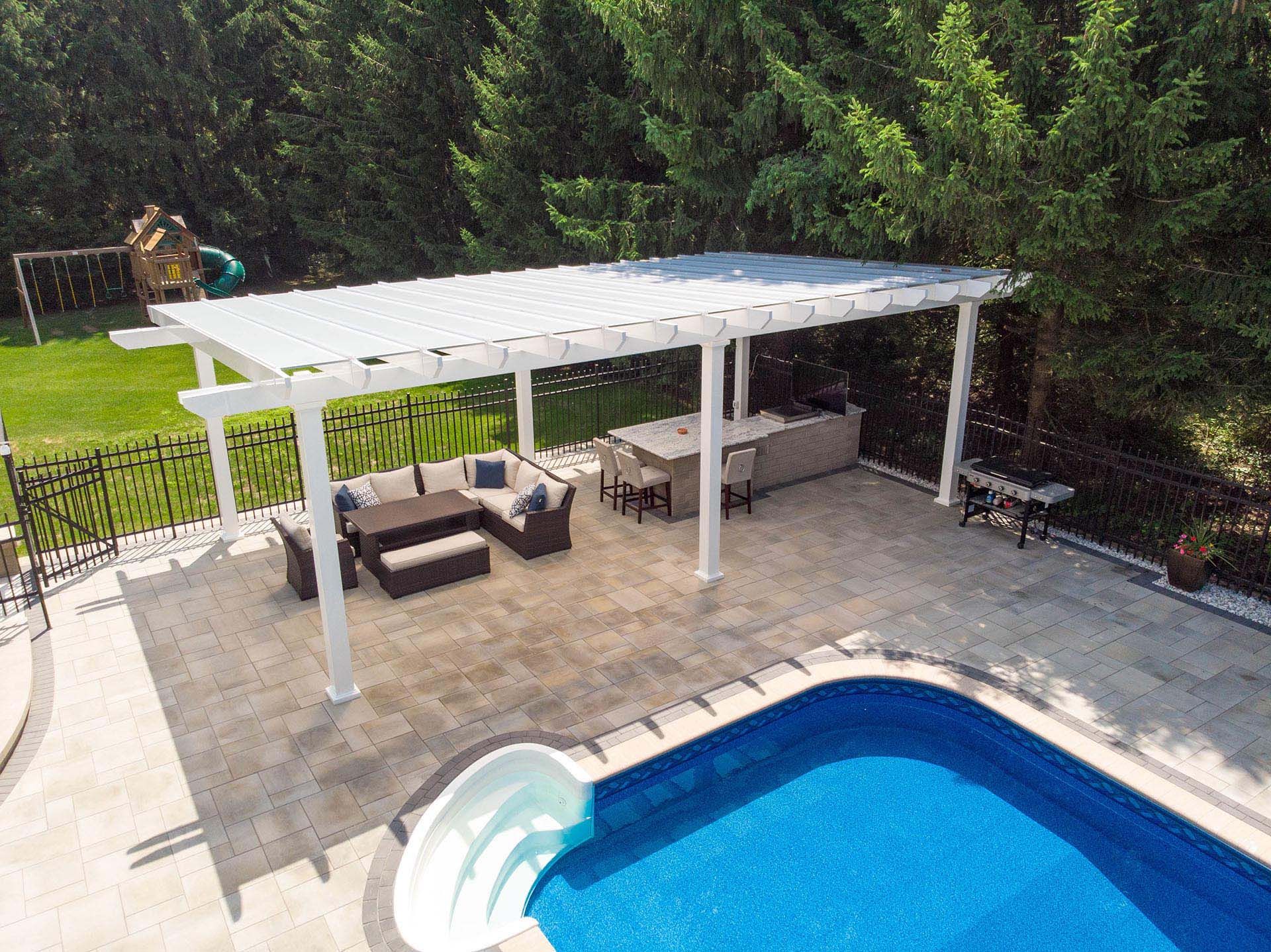 An aerial view of a white pergola near a pool