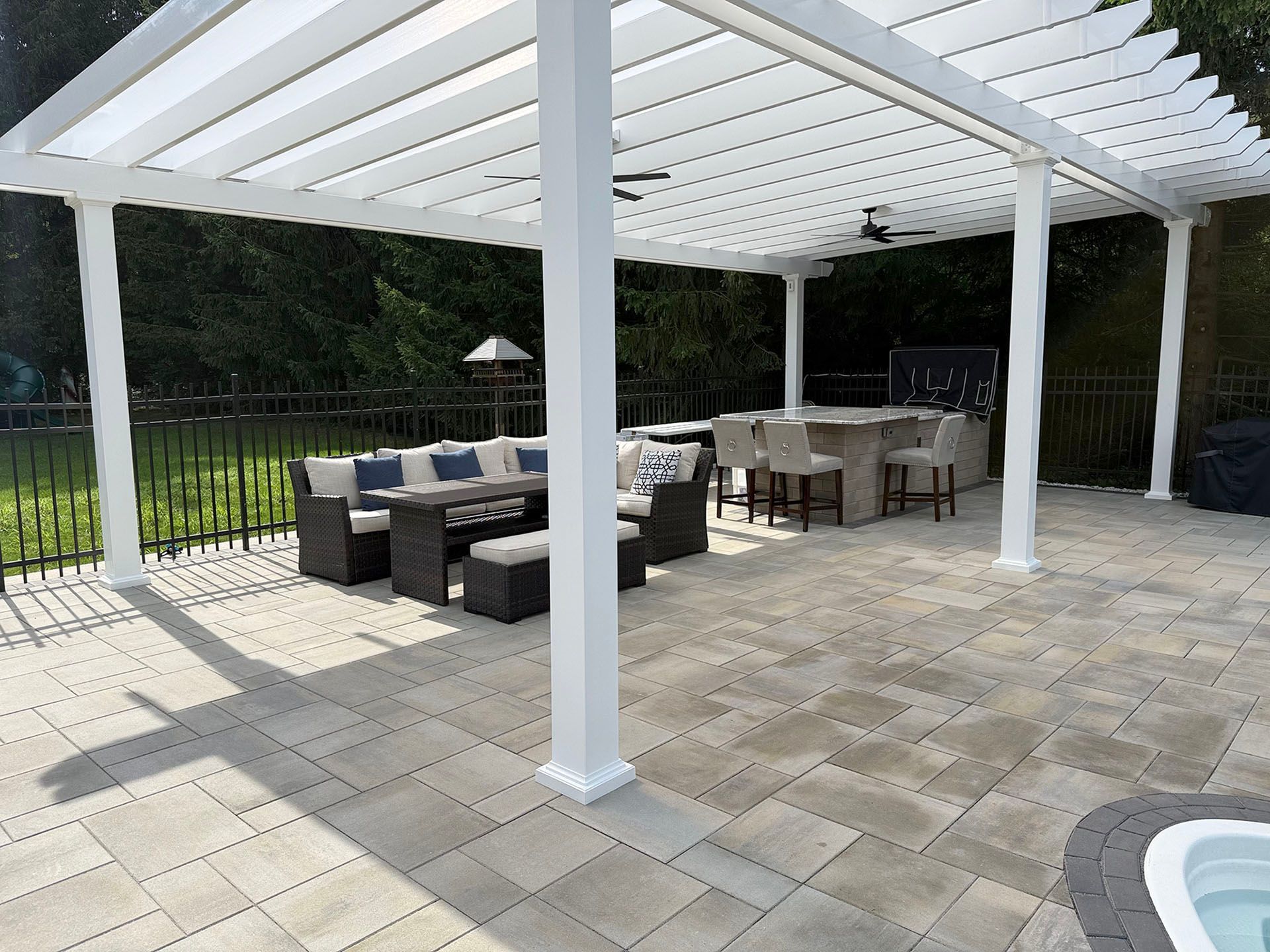 A white pergola with outdoor seating 